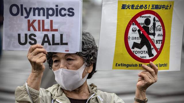 Veel inwoners van Tokio zitten vanwege het oplopende aantal coronabesmettingen nog altijd niet te wachten op de Olympische Spelen en protesteerden bij het overdragen van de vlam.