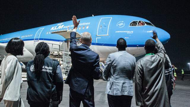 De Nederlandse ambassadeur in Rwanda Matthijs Clemens Wolters (midden) en VN-vertegenwoordiger Fodey Ndiaye (rechts) zwaaien naar KLM-piloten tijdens de aankomst van de eerste 103.000 doses van het vaccin van Pfizer/BioNTech op de luchthaven van de Rwandese hoofdstad Kigali.