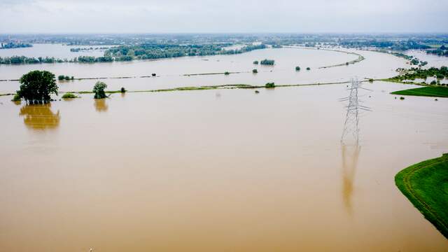 Deze dronefoto van de hoge waterstand in de Maas is gemaakt bij het gehucht Aasterberg in het midden van Limburg. De rivier is hier ver buiten zijn oevers getreden.