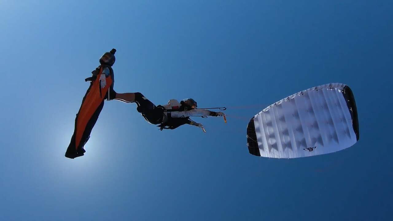 Beeld uit video: Parachutespringer surft op rug van wingsuitvlieger