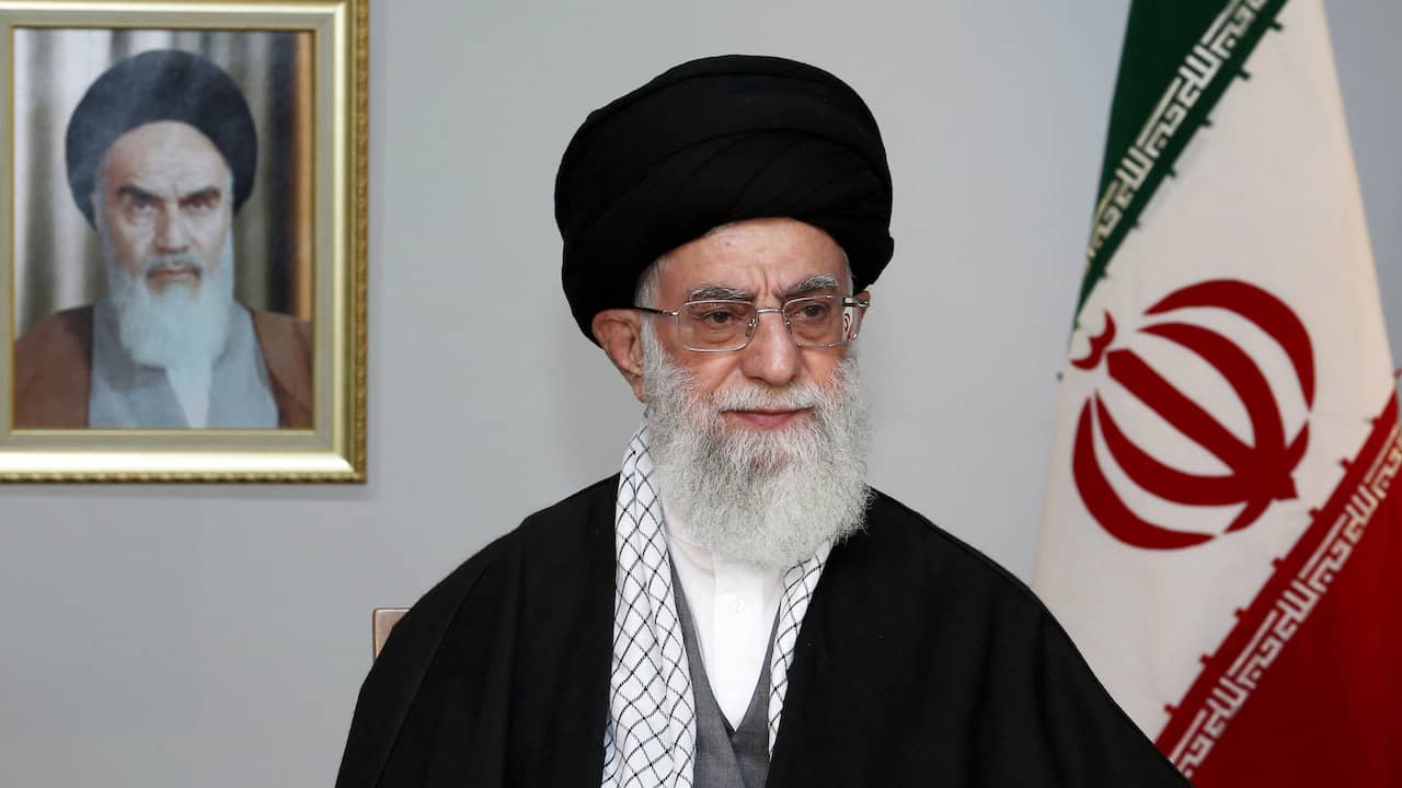 Ali Khamenei, Pemimpin Tertinggi Iran saat ini.  Di belakangnya tergantung potret pendahulunya, Ruhollah Khomeini.