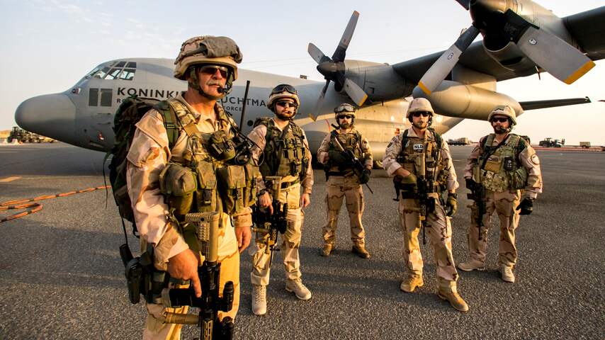 Nederlandse militairen staan bij een C-130 transportvliegtuig