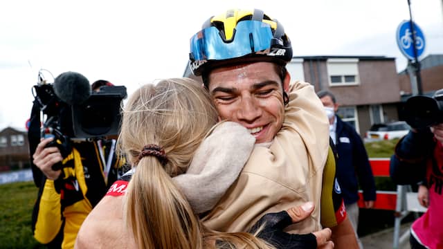 Een dolgelukkige Wout van Aert valt na de finish in de armen van zijn vrouw.