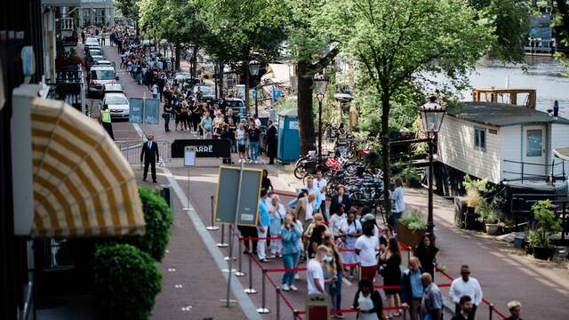 De rij in het centrum van Amsterdam reikt inmiddels tot aan het Frederiksplein en is bijna 1 kilometer lang. Er zijn extra hulpverleners opgeroepen, omdat het er erg druk is.