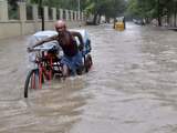 Een man duwt zijn fiets voort in de overstroomde Indiase stad Chennai.