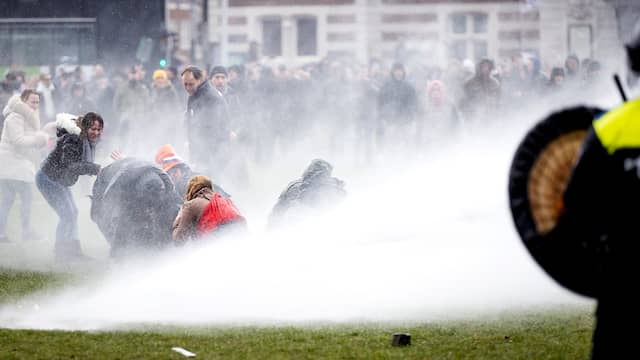 Een deel van de betogers kiest eieren voor zijn geld en vertrekt. Toch blijft een aanzienlijke groep staan. De demonstranten die blijven, krijgen een nat pak.