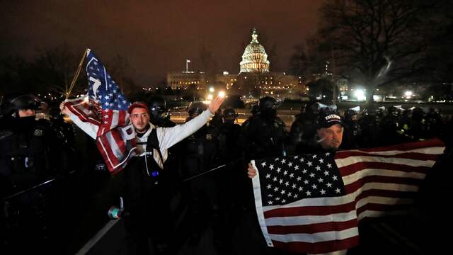 Trump-aanhangers verlaten het Capitool na de storm.