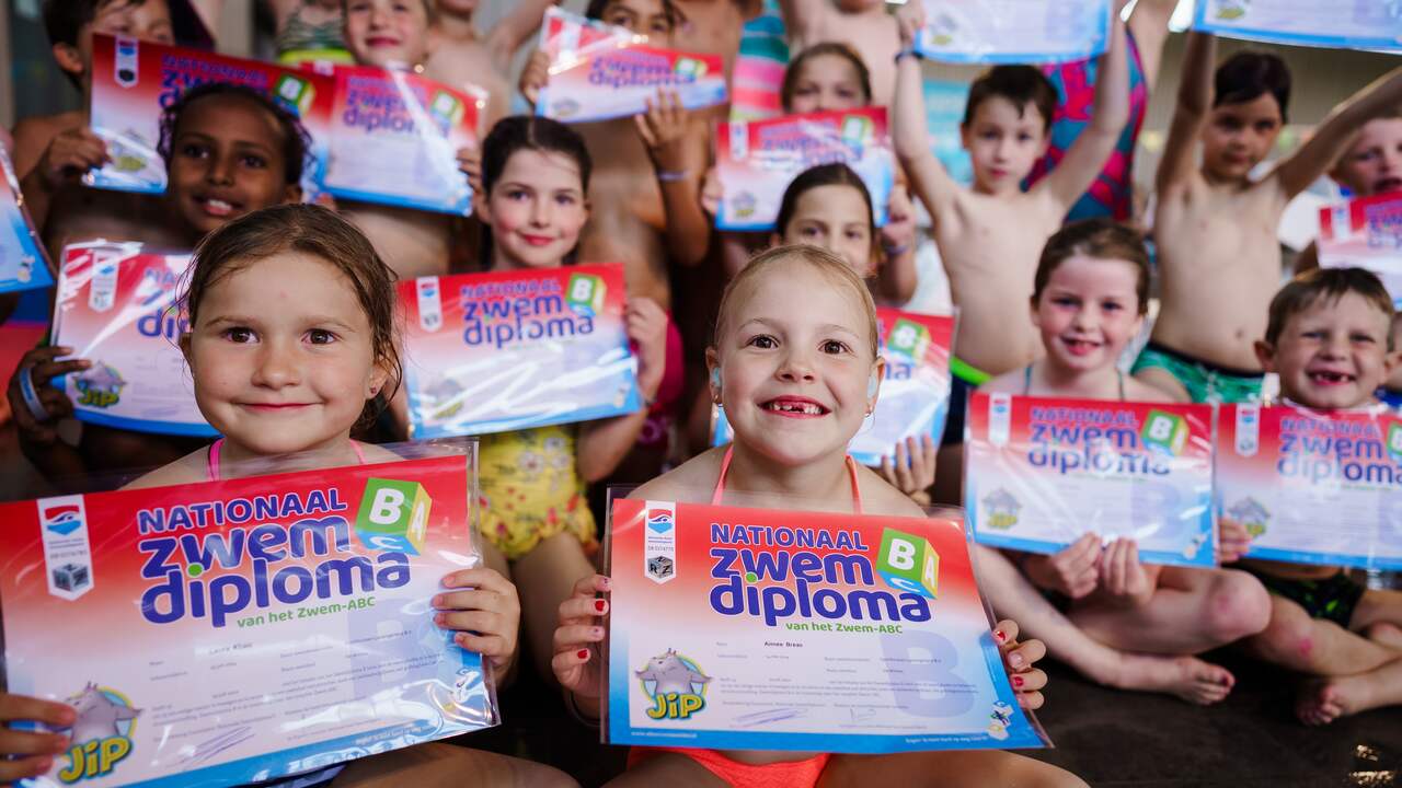 Kinderen tonen hun diploma na afloop van het afzwemmen.