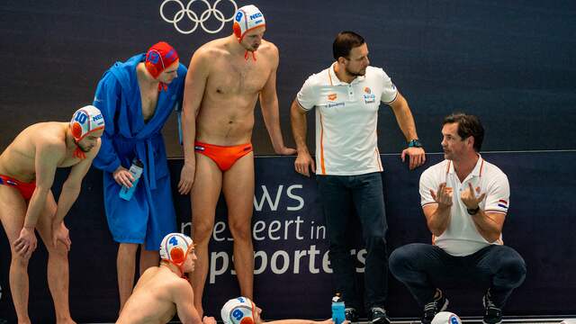 De waterpoloërs luisteren naar de aanwijzingen van bondscoach Harry van der Meer (rechts).