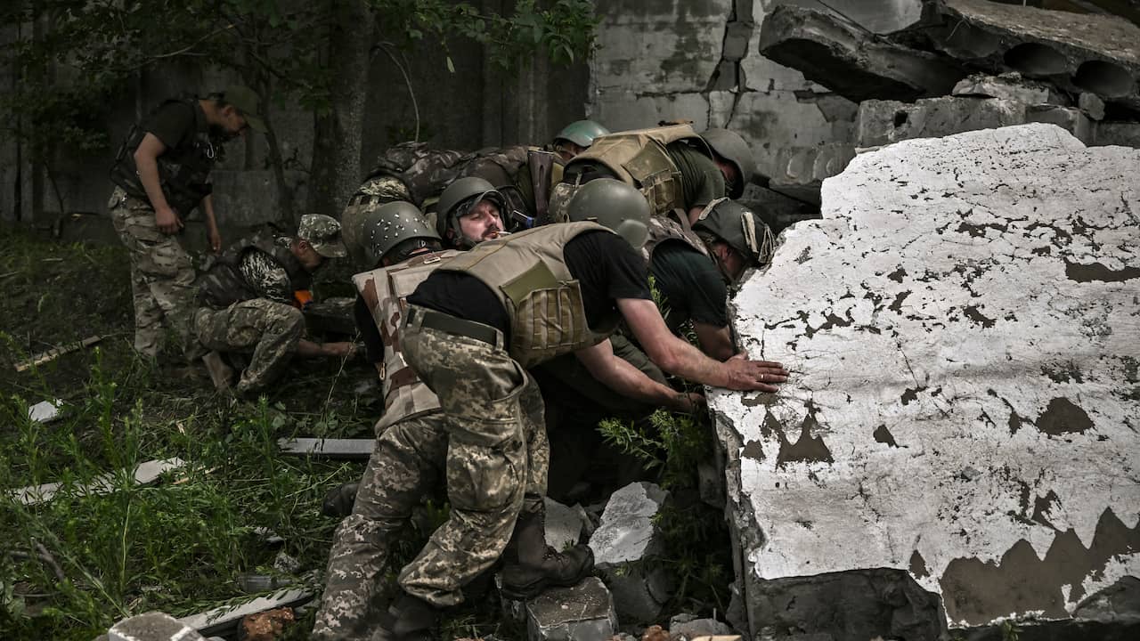 Ukrainian soldiers investigate a bombed warehouse.