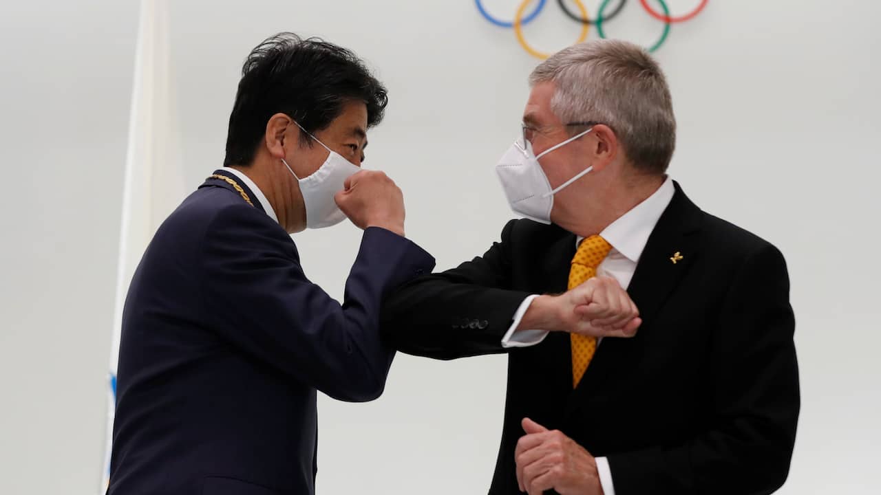 IOC-voorzitter Thomas Bach en de voormalige Japanse premier Shinzo Abe begroeten elkaar.
