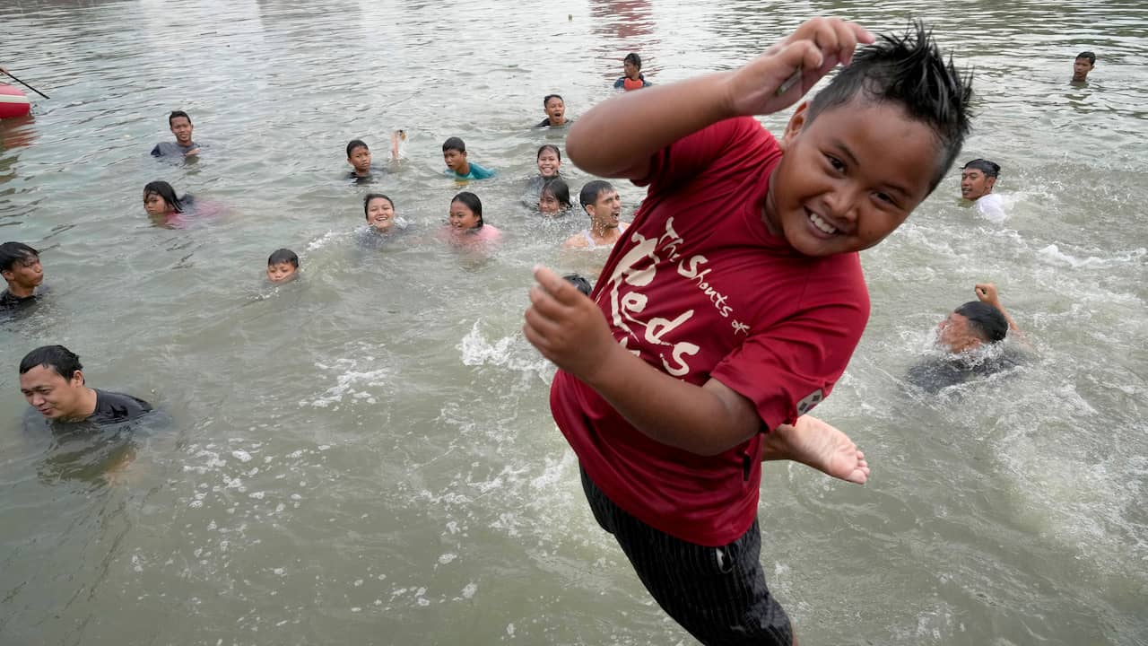 Anak-anak menyelam di sungai.