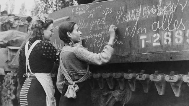 1944: Nederlandse meisjes schrijven na de bevrijding van Breda boodschappen op een Poolse Sherman-tank.