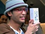 Een man toont zijn net aangeschafte iPhone 5S bij de Apple Store in Tokio.
