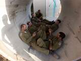 Israëlische soldaten rusten uit in een cementpijp die dienstdoet als beschutting tegen raketaanvallen.