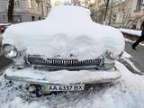 Een ingesneeuwde auto in de Oekraïense hoofdstad Kiev.