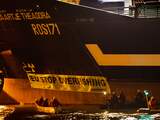 Actievoerders van Greenpeace bij het vastgeketende schip Maartje Theadora in de haven van IJmuiden.