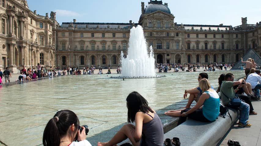 Mensen zoeken verkoeling in het fontein bij het Louvre