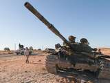 Een Libische rebel passeert een tank die per abuis door de NAVO was vernietigd. Het voertuig was aanvankelijk van het Libische regime, maar de rebellen hadden deze overgenomen, iets waar de NAVO niet van op de hoogte was.