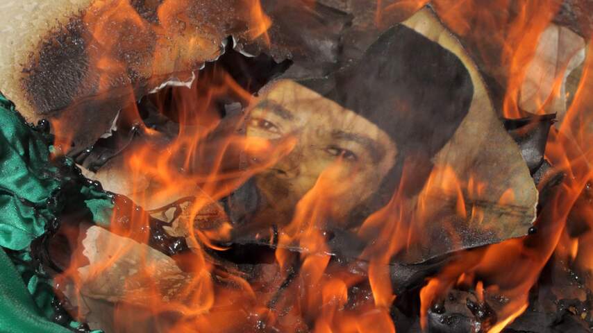 Poster van Kaddafi wordt verbrand