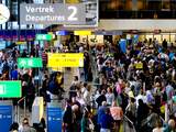 Drukte op vrijdag in vertrekhal 2 op Schiphol. Het komende weekeinde is voor de luchthaven het drukste van het jaar. De verwachting is dat er 453.000 mensen via Schiphol zullen reizen. 