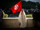 Een man houdt zaterdag een vlag op tijdens een nieuwe demonstratie in de Tunesische hoofdstad Tunis.