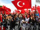 Aanhangers van Erdogan wachten hem zondag op bij aankomst op het vliegveld in Ankara.