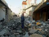Een soldaat staat bij de vernielde huizen in Irak. De VN maakte donderdag bekend dat er in 2012 in Irak meer burgerdoden zijn gevallen door het geweld daar. 