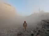 Een lid van de Syrische oppositie loopt door Aleppo na een vermeende luchtaanval van het Syrische leger.