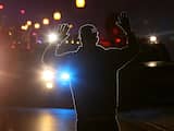 Een man houdt zijn handen in de lucht voor de politie.