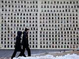 People pass a wall with portraits of Ukrainian soldiers who have died in the conflict in eastern Ukraine, in the Andriyivskyy Descent street in downtown Kiev, Ukraine, 12 February 2015.