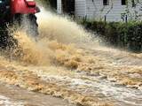Vrijdag 2 november: Een traktor rijdt door het water, dat door een overstroming van de Franse rivier Liane op de weg terecht gekomen is.