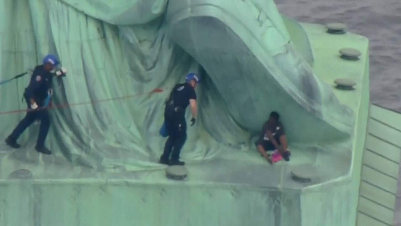 Beeld uit video: Politie haalt demonstrant van Vrijheidsbeeld