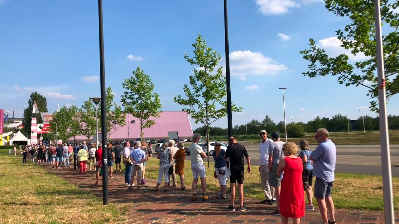 Lange rij bij GGD in Enschede voor vaccinatiestempel in gele boekje