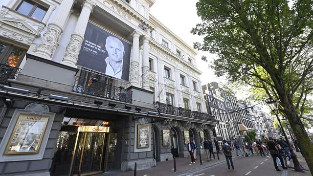 Op de gevel van Carré is een foto van De Vries te zien met de tekst: "On bended knee is no way to be free." Deze woorden had de misdaadverslaggever op zijn lijf laten tatoeëren.