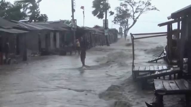 Water stroomt door verwoeste straten Bangladesh na cycloon