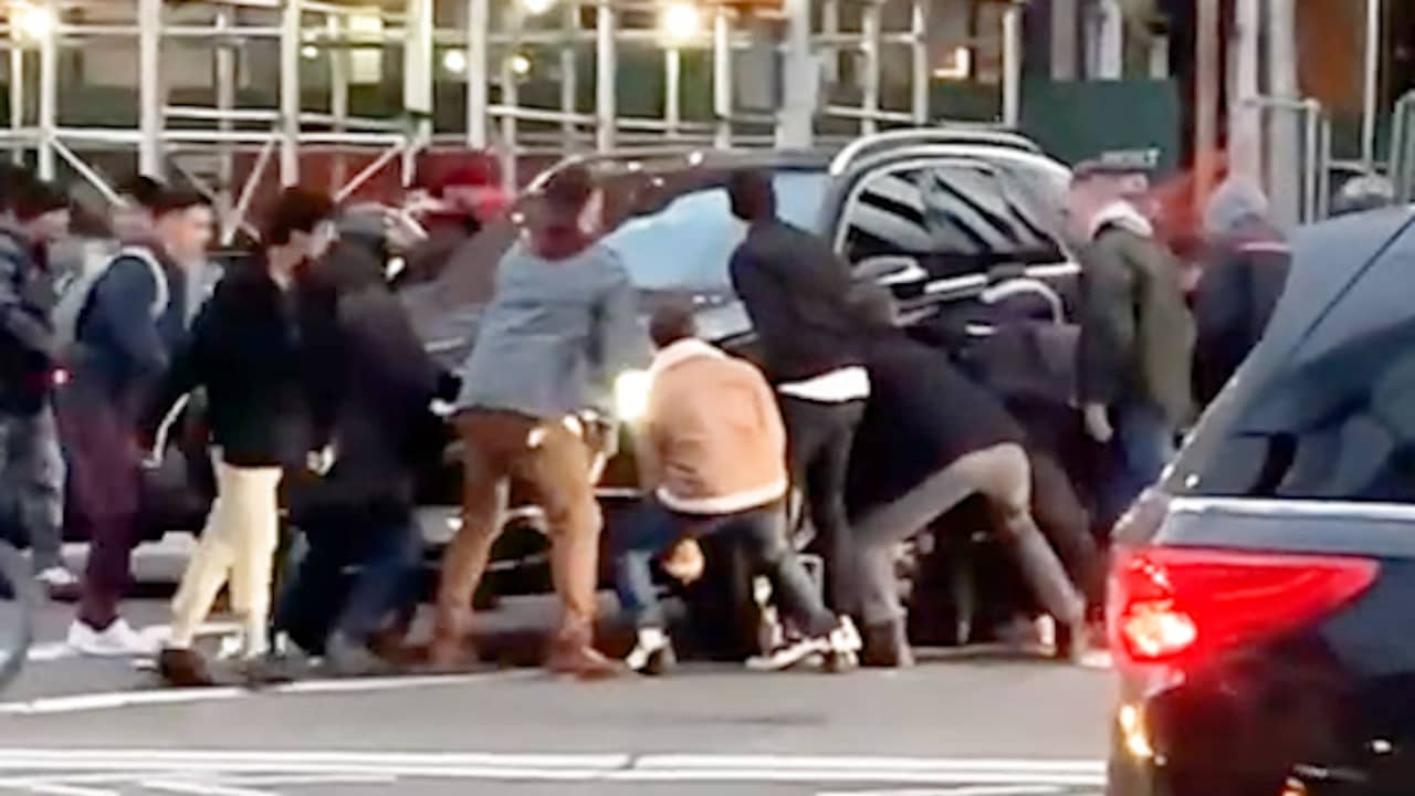 New Yorkers tillen SUV op om beknelde vrouw te redden