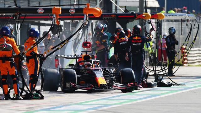Max Verstappen rijdt weg na zijn trage stop in Italië.