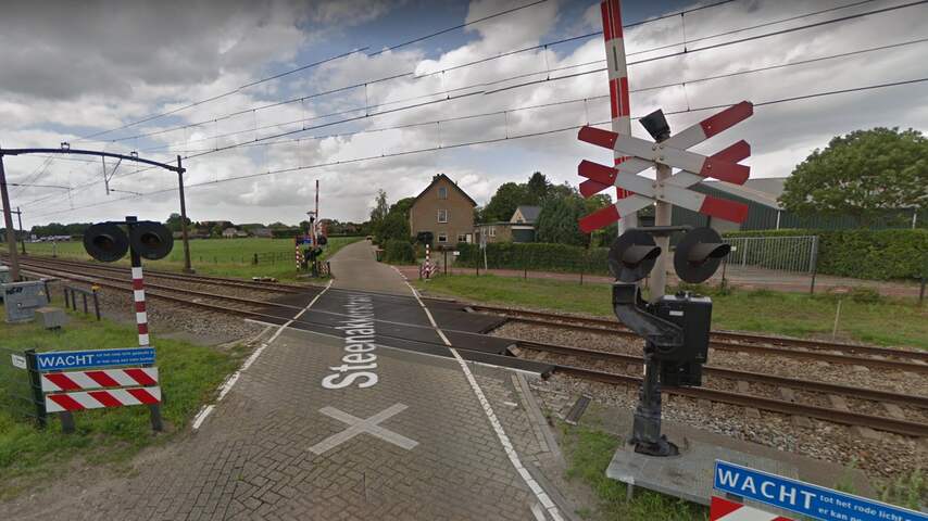 Auto belandt onder trein op spoorwegovergang in Breda, geen gewonden