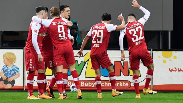 Spelers van Freiburg vieren feest na een goal tegen Dortmund.