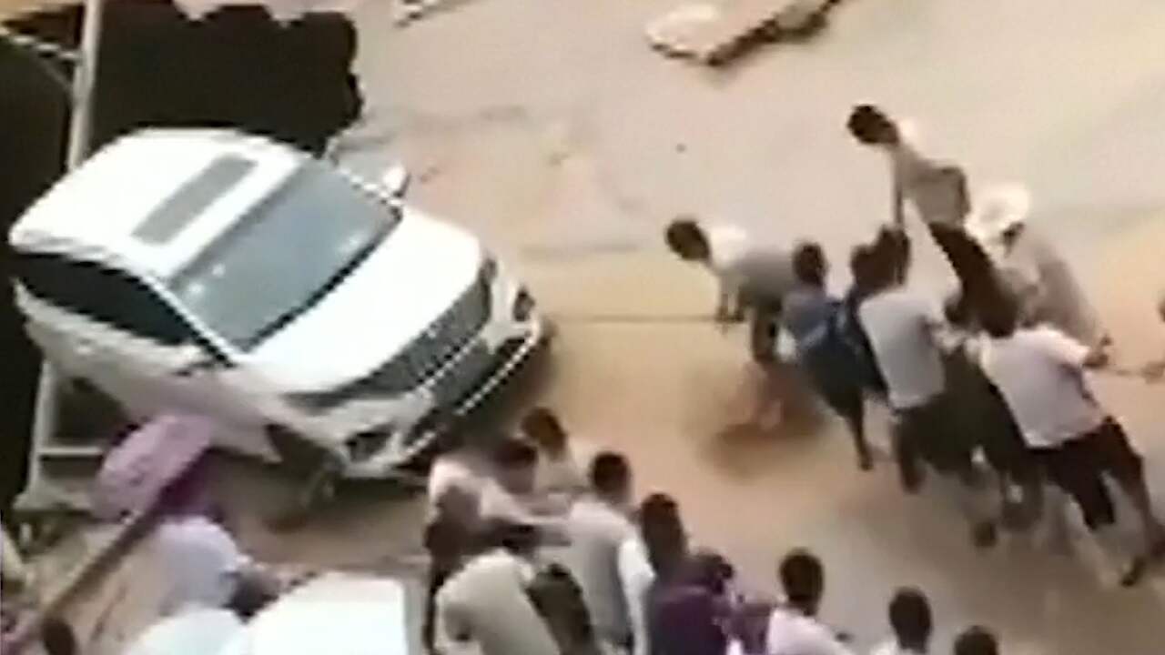 Beeld uit video: Omstanders slepen auto weg van rand sinkhole China