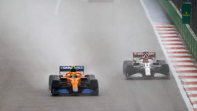 Lando Norris (links) glibbert over de natte baan in Rusland.