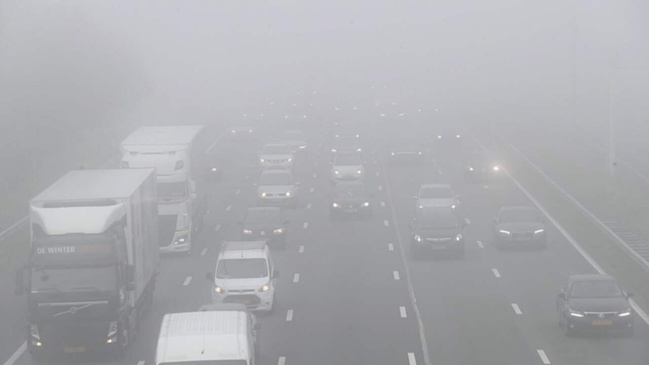 Automobilisten rijden in dichte mist op snelweg bij Schiphol