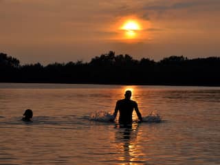 genietend in het water van en mooie zonsondergang op maandag