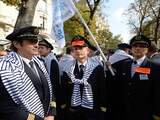 Air France pilots of the SNPL, Air France's main pilots union, and the Spaf union demonstrate in their uniform, and with a striped sweater onto their shoulders, on September 23, 2014 near the National Assembly building in Paris. French Prime Minister Manuel Valls warned of a "real danger" for Air France as a pilot strike that has grounded more than half its fleet deepened on September 23 after talks hit an impasse. The strike over plans to expand the company's budget airline Transavia in Europe entered its ninth day at a cost of 20 million euros ($25.7 million) daily. The stickers read "Pilots on strike, united for our future". AFP PHOTO / ERIC FEFERBERG