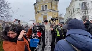Oekraïense priester besprenkelt journalisten met water