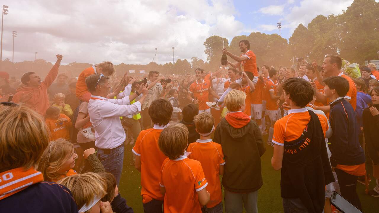 De spelers van Bloemendaal vieren het kampioenschap met de supporters.