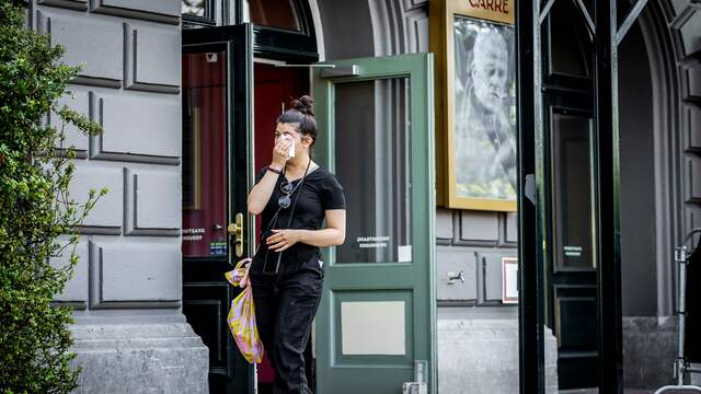Een geëmotioneerde bezoeker verlaat theater Carré.