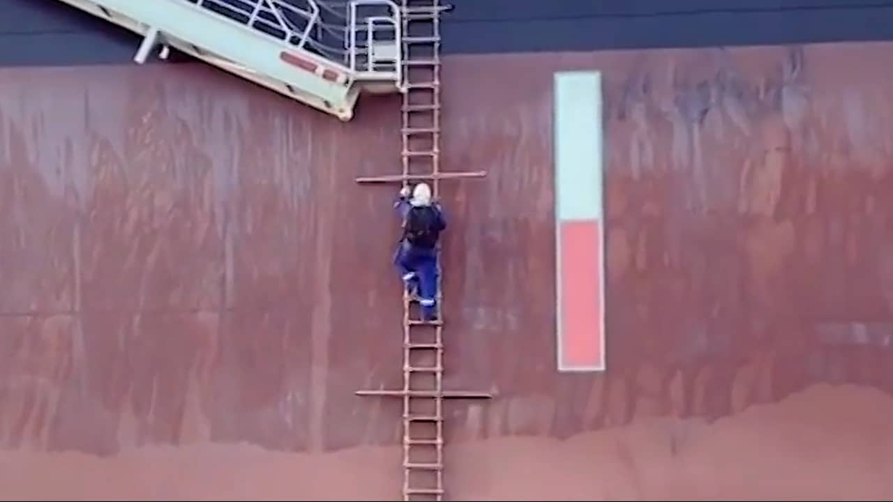 Beeld uit video: Inspecteur in Rotterdamse haven klimt via ladder op varend schip