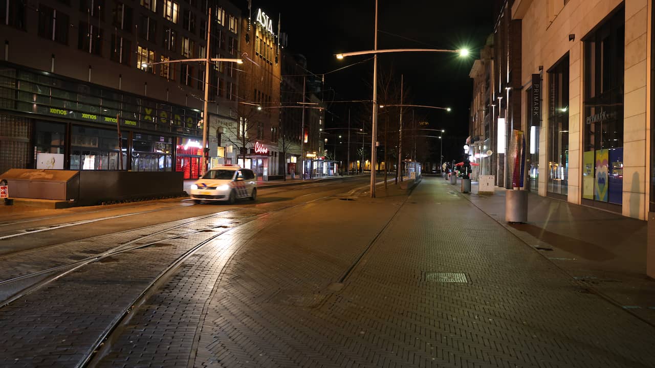 Politieagenten rijden over het vrijwel geheel verlaten Spui in Den Haag.